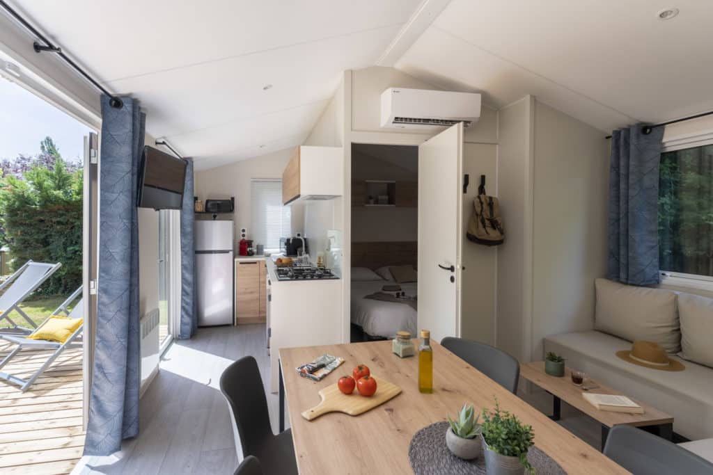 Intérieur lumineux d'un mobil-home moderne avec terrasse.
