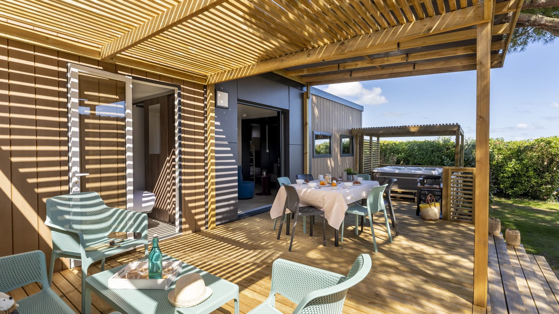 Terrasse en bois avec pergola et chaises extérieures.